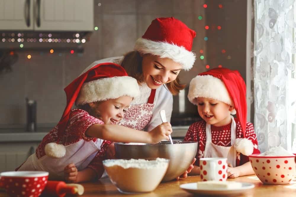 happy mom baking with two young kids