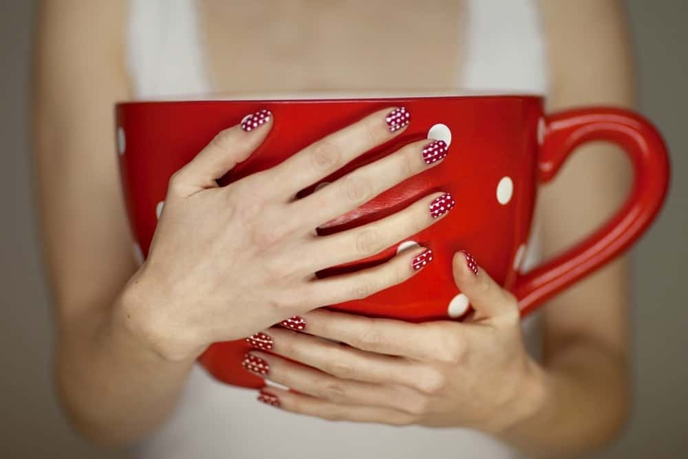 woman holding giant coffee cup