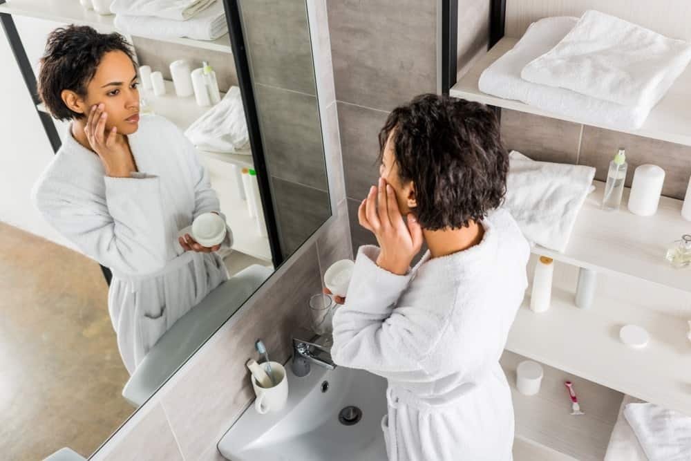 young woman applying moisturizer