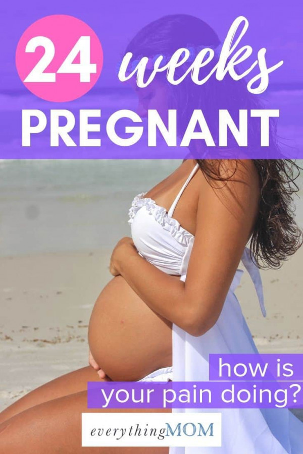 24 weeks pregnant goddess woman at beach in swimsuit holding stomach